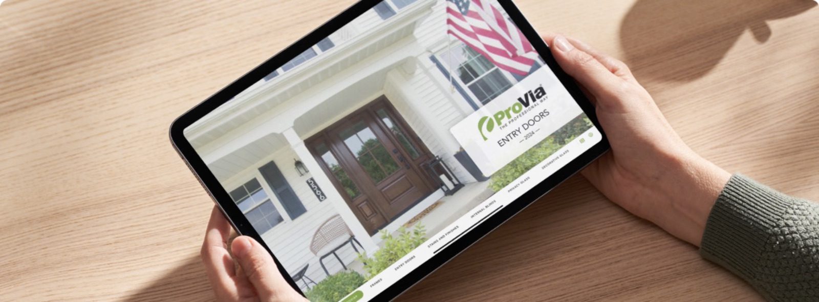 Hands holding an iPad showing a ProVia entry doors presentation